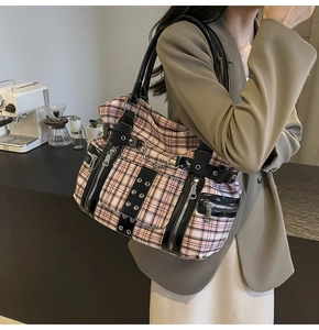 Detail of pink plaid gothic tote bag with metal chains and black patent leather trim