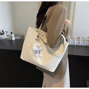 Close-up of creamy white tote bag with lychee grain texture and cute cloud charm detail