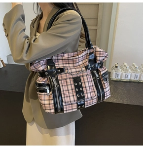 Detailed shot of pink and black plaid punk tote bag with silver eyelets and metal chains