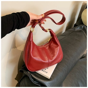 Close-up of red oil-wax PU leather shoulder bag with gold zipper and adjustable strap