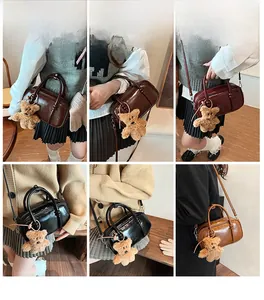 Dettaglio di mini borse da bowling in pelle PU con ciondolo a forma di orso in vari colori