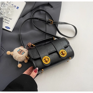 Detailaufnahme der schwarzen Mini-Boston-Bag mit weißen Nähten und goldenen Schlössern