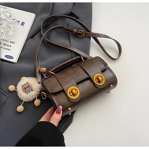 Détails du sac oreiller marron rétro avec fermoirs dorés et petit pendentif lion créatif