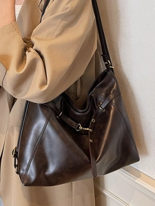 Large dark brown leather tote bag with gold buckle hardware and adjustable shoulder strap