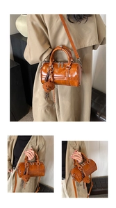 Detail of caramel brown Boston bag with adjustable strap and plush bear charm