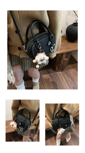 Detail of black mini Boston bag with heart patches and white plush bear charm