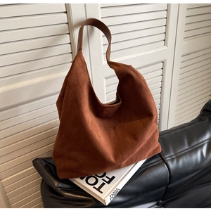 Close-up of brown suede hobo bag texture and smooth leather strap in a stylish setting