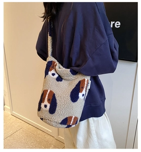Detail view of plush faux shearling tote bag with cartoon dog pattern on a model