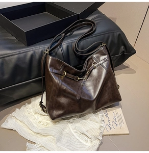 Detail showing high-quality dark coffee leather texture and vintage brass ring buckle