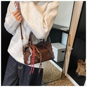 Vue détaillée du sac Boston en cuir ciré marron avec tirette de fermeture tissée décorative