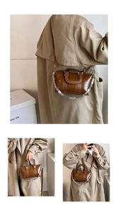 Detail of dark brown glossy leather handbag with vertical lines and silver chain strap