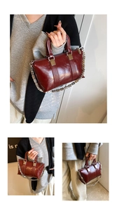 Macro view of burgundy crossbody bag with silver chain detail and polished hardware