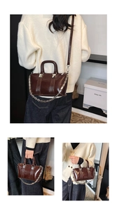 Detailed view of the dark brown glossy leather handbag with chunky silver metal chain strap