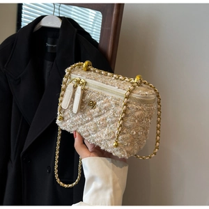 Detail of tweed crossbody bag with golden camellia metal floral ornament and chain strap