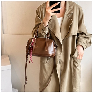 Sac Boston marron en cuir huilé brillant avec ruban décoratif à carreaux rouges