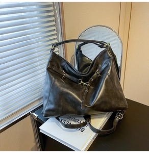 Detail view of deep brown faux leather tote with metallic eyelets and retro gold hooks