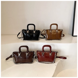Detail view of mini glossy leather crossbody bags in four colors with silver chain straps