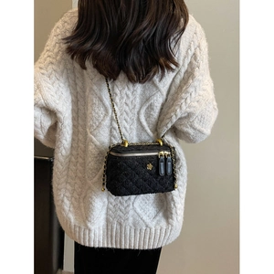 Quilted tweed crossbody phone bag with chain strap and gold floral accent on white sweater