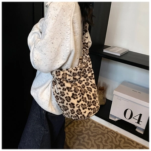Macro detail of the plush faux fur leopard print bag featuring a woven MISS label