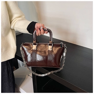 Detailed view of glossy dark brown oil wax leather bag with silver G-link chain strap
