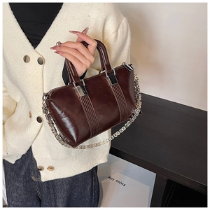 Detail of vintage dark brown Boston bag with silver chain strap and stitched accents