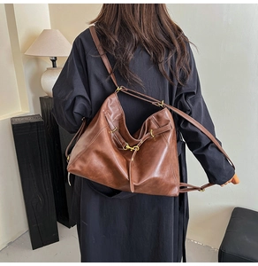 Detailed shot of dark brown matte leather tote bag with metallic buckle and adjustable strap