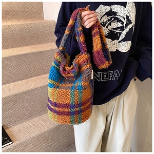 Detail of colorful plaid faux shearling tote bag with soft teddy texture and wide strap