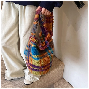 Close-up of colorful checkered faux shearling tote bag with fuzzy wool-like texture