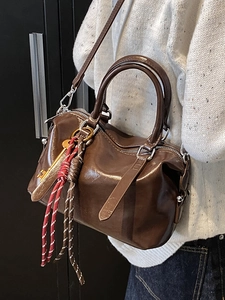 Sac Boston en cuir ciré marron foncé avec pendentifs tressés et quincaillerie argentée