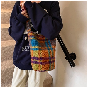 Close-up of colorful checkered faux fur tote bag with soft teddy wool texture and crossbody strap