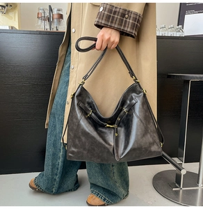 Detail view of large dark brown leather tote bag with glossy finish and metal hardware