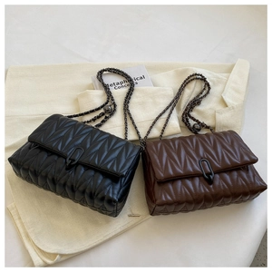 Detail view of quilted V-pattern leather chain bags in black and dark brown colors