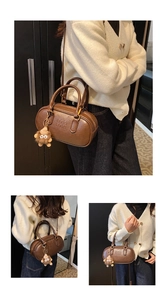 Vue détaillée du sac cylindrique marron montrant le logo embossé et le grigri