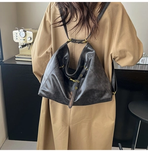 Detail of vintage matte black leather backpack with brass buckles and adjustable straps