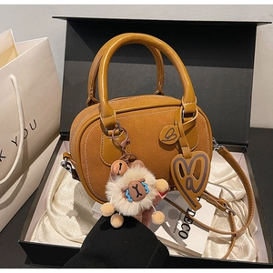 Detail of ginger matte leather Boston bag with sheep charm in a premium gift box
