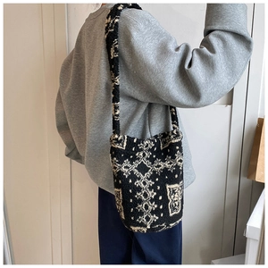 Detail of plush bucket bag featuring black and white geometric jacquard and soft wool texture