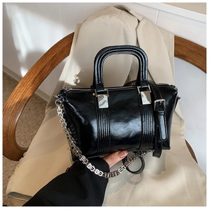 Detail shot of the black textured leather handbag with square link silver chain