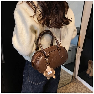 Détail du sac bowling rétro marron foncé avec logo ATN et breloque peluche monstre
