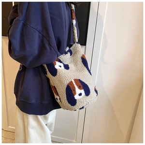 Close-up of fluffy sherpa tote bag featuring a cute cartoon dog pattern on a model