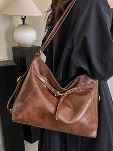 Minimalist brown large capacity tote bag shown as a shoulder bag in a retro chic style