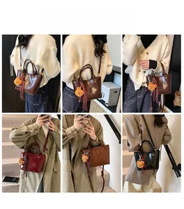 Dettaglio della mini borsa a secchiello con ciondolo a orsetto e foulard in seta decorativo