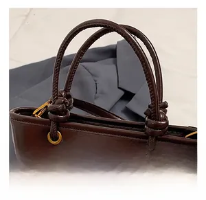 Dettagli della borsa in pelle color caffè con manico a nodo e occhielli oro vintage