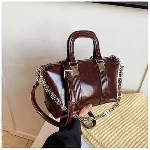Detail of a dark brown glossy Boston bag featuring silver metal chain and smooth PU leather