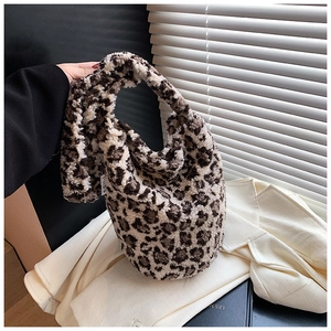 Detail of leopard print plush bucket bag with soft faux fur texture and side woven label