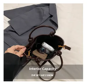 Capacità interna della borsa a secchiello in pelle marrone scuro con telefono e trucco