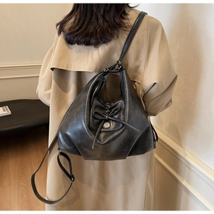 Detailed view of the black faux leather tote bag with bow detail and silver metal buckle