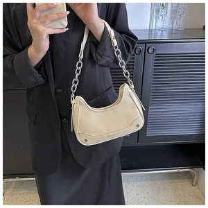 Vue détaillée du sac hobo crème avec bandoulière chaîne argentée et texture de cuir