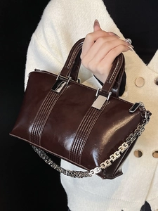 Chic dark brown patent leather handbag with stylish silver chain for business commuting