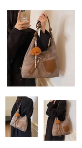 Dettaglio della borsa tote marrone con cerniere decorative e ciondolo a forma di cane
