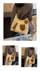 Dettaglio della borsa tote in tela con tasche in pelle marrone e ciondolo a orsetto